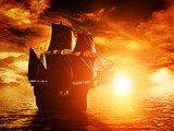 Ancient pirate ship sailing on the ocean at sunset  Pojazdy Fototapeta