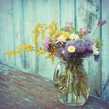 bouquet of garden flowers and healing herbs in glass jug on old  Plakaty do Salonu Plakat