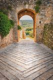 Exit the town of Monteriggioni with views of the Tuscan landscap  Fototapety Uliczki Fototapeta