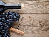 Bottle of wine, corkscrew and grape on wooden background  Obrazy do Kuchni  Obraz