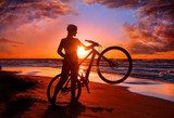 Woman with bicycle on the beach  Sport Fototapeta