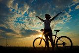 Biker-girl at the sunset on the meadow  Sport Fototapeta