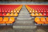Rows of red and orange plastic sits at stadium  Stadion Fototapeta
