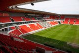 View on an empty football (soccer) stadium with red seats  Stadion Fototapeta