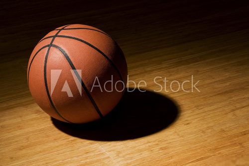 Basket ball sitting on wood floor  Stadion Fototapeta