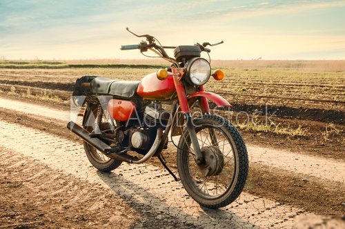 Classic old motorcycle on a dirt road.  Pojazdy Fototapeta