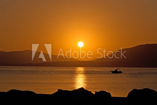 Świecące nad taflą wody Zachód Słońca Fototapeta