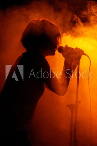 Concert photo of female singer holding microphone  Ludzie Plakat