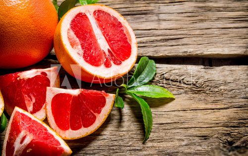 Fresh cut grapefruit with leaves. On wooden table. Owoce Obraz