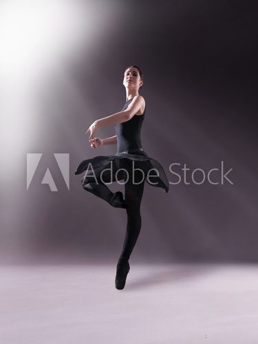 Ballerina in black outfit posing on toes, studio background Fototapety do Szkoły Tańca Fototapeta
