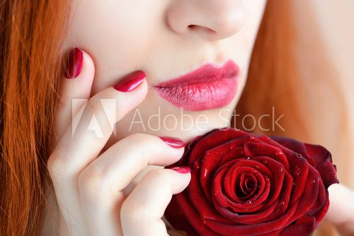Portrait with red rose flower. Dark red lips and nails. Beautiful red-haired young woman. Obrazy do Salonu Kosmetycznego Obraz