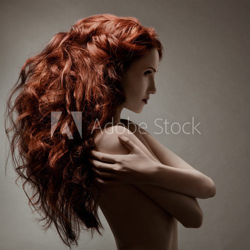 Beautiful woman with curly hairstyle against gray background  Obrazy do Salonu Fryzjerskiego Obraz