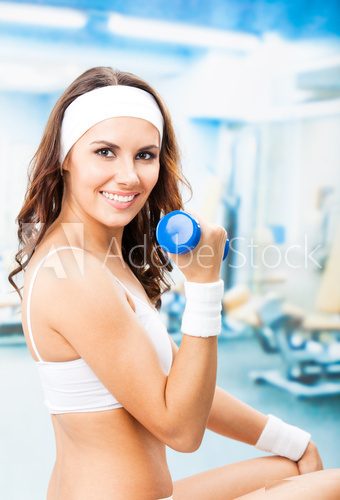 Woman exercising with dumbbell, at fitness center  Fototapety do Klubu Fitness Fototapeta
