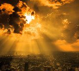 Rays of light shining through dark cloud  Zachód Słońca Fototapeta