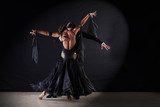 Latino dancers in ballroom against on black background  Ludzie Obraz