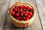Sweet cherries in wicker basket on wooden table  Plakaty do kuchni Plakat