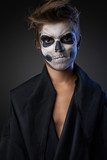 Teen with make-up of skull in black cloak unhappy  Ludzie Obraz