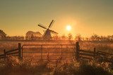 Fence and windmill in the Dutch countryside.  Obrazy do Salonu Obraz