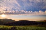Sky with clouds in hilly countryside in sunset or sunrise time  Fototapety Góry Fototapeta