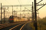 Freight train moving on the tracks at sunset Industrialne Fototapeta