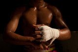 The muscular fighter tying tape around his hand preparing to box  Sport Plakat