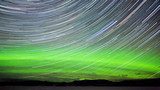Star trails and Northern lights in night sky  Niebo Fototapeta