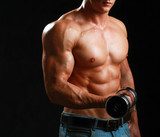 Handsome muscular man working out with dumbbells  Fototapety do Siłowni Fototapeta