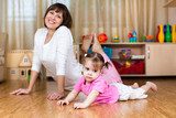 Mother and her child doing exercises together in home interior  Fototapety do Klubu Fitness Fototapeta