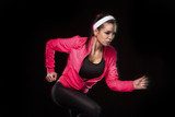 Beautiful young jogging woman. Isolated over black background (c  Fototapety do Klubu Fitness Fototapeta