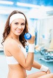 Woman exercising with dumbbell, at fitness center  Fototapety do Klubu Fitness Fototapeta
