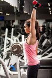 Cute young woman lifting weights  Fototapety do Klubu Fitness Fototapeta