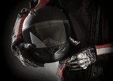 Motorcyclist with helmet in his hands. Dark background  Sport Fototapeta