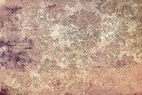 Delicate vintage patterns gracefully intertwine on this distressed backdrop, showcasing subtle earth tones and intricate detailing. Perfect for enhancing designs requiring a touch of nostalgia Mur Fototapeta