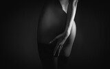 Light art on a woman's slender naked body. Buttocks. Erotyka Obraz