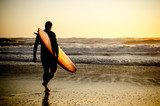 Surfer w blasku zachodzącego słońca nad oceanem Sport Fototapeta