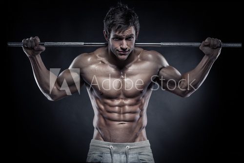 Muscular bodybuilder guy doing exercises with dumbbells over bla  Ludzie Plakat