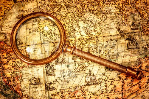 Vintage magnifying glass lies on an ancient world map  Mapa Świata Fototapeta