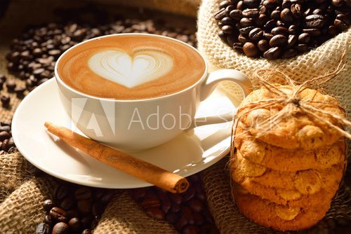 A cup of cafe latte with coffee beans and cookies  Fototapety do Kawiarni Fototapeta