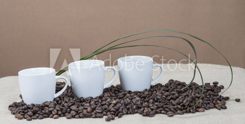 Tres tazas de cafÃ© sobre un montÃ³n de granos.  Kawa Fototapeta