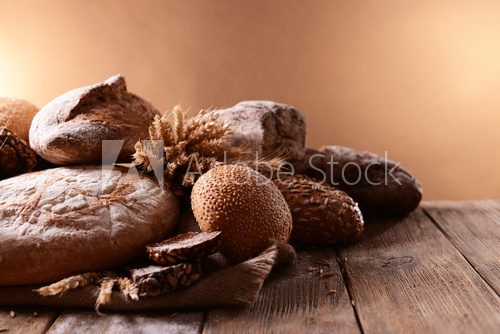 Different bread on table on brown background  Obrazy do Jadalni Obraz