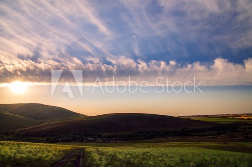 Sky with clouds in hilly countryside in sunset or sunrise time  Fototapety Góry Fototapeta