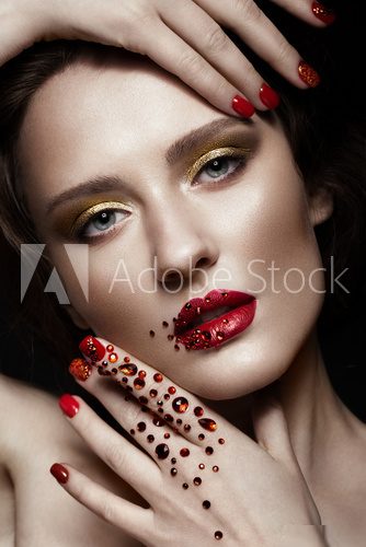 Beautiful girl with evening make-up, red lips in rhinestones and design manicure nails. beauty face. Photos shot in studio Obrazy do Salonu Kosmetycznego Obraz