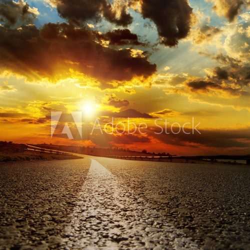 asphalt road and dramatic sunset over it  Niebo Fototapeta