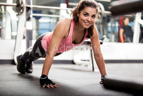 Beautiful girl working out in a gym  Fototapety do Klubu Fitness Fototapeta
