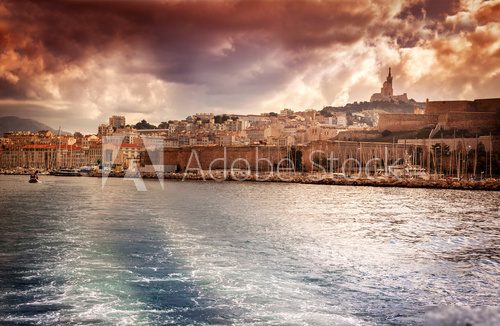 view of the city and sea port on the background of dramatic suns  Prowansja Fototapeta