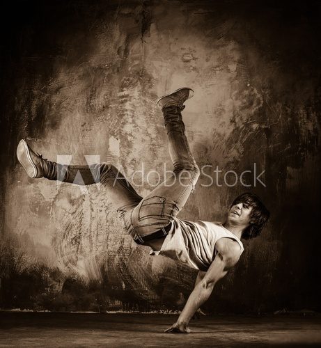 Young man with naked torso doing acrobatic movements  Fototapety Sepia Fototapeta