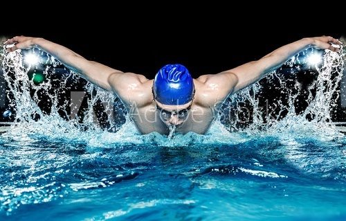 Muscular young man in blue cap in swimming pool  Sport Fototapeta