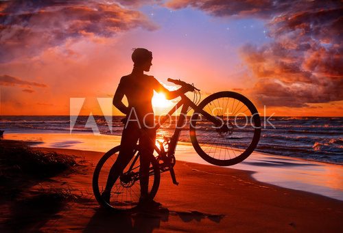 Woman with bicycle on the beach  Sport Fototapeta