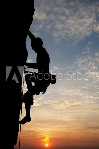 silhouette of climber on rock face  Sport Fototapeta