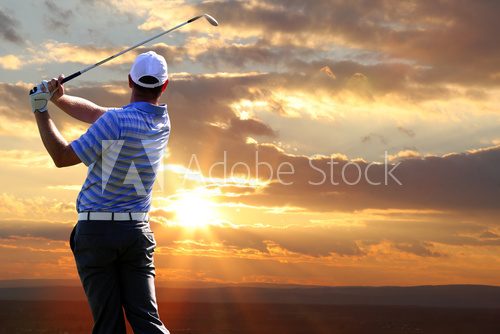 Man playing golf against sunset  Sport Fototapeta